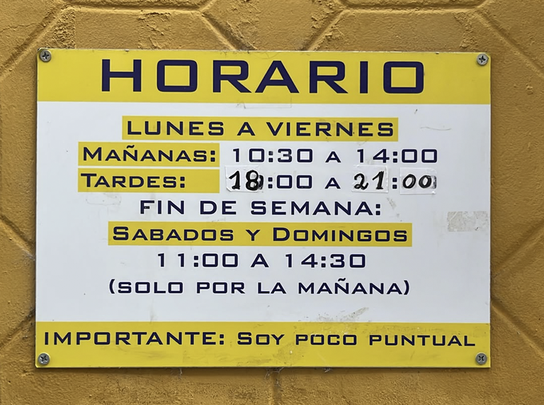 Cartel del horario de una tienda abierta de lunes a domingo, con el aviso «Importante: soy poco puntual».