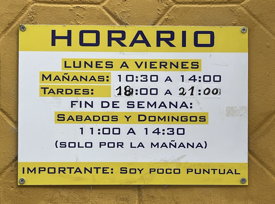 Cartel del horario de una tienda abierta de lunes a domingo, con el aviso «Importante: soy poco puntual».